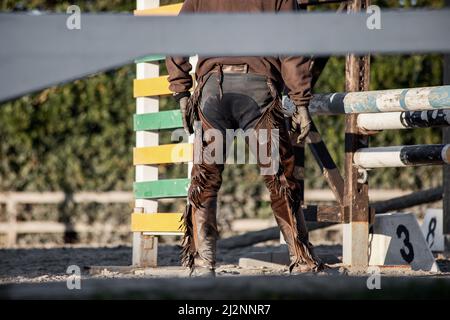 Ranch LIFE, vista posteriore di un cowboy che indossa dei zappini mentre lavora in paddock Foto Stock