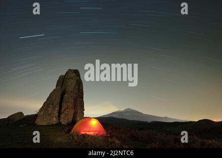 Sentieri stellari su tenda illuminante e megalite dell'Altopiano di Argimusco, Sicilia Foto Stock