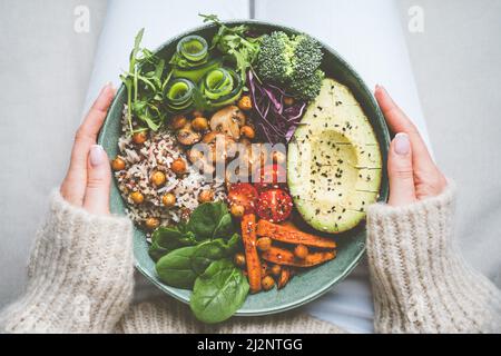 Donna che tiene piatto con cibo vegano o vegetariano. Ciotola di Buddha con verdure fresche. Mangiare sano Foto Stock