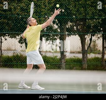 Iniziamo. Sparo a tutta lunghezza di un bel giocatore di tennis maschile maturo che serviva durante la sua partita. Foto Stock