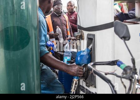 Nakuru, Kenya. 02nd Apr 2022. Un assistente riempie una bottiglia di plastica di olio mentre altri motociclisti aspettano. Il Kenya è stato colpito da una grave carenza di petrolio con lunghe code da parte degli automobilisti in attesa di essere serviti in alcune stazioni di benzina che hanno ancora il prodotto essenziale. La regolamentazione energetica e petrolifera del Kenya (EPRA) ha attribuito la carenza a sfide logistiche senza precedenti. I prezzi globali del petrolio sono stati influenzati dalla guerra Russia-Ucraina che ha spinto il prezzo a 14 anni al massimo. (Foto di James Wakibia/SOPA Images/Sipa USA) Credit: Sipa USA/Alamy Live News Foto Stock