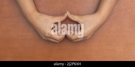 Forma del cuore creata dalle mani della bambina. Bel momento emotivo e sentimentale. Concetto di amore, felicità e sicurezza. Foto Stock