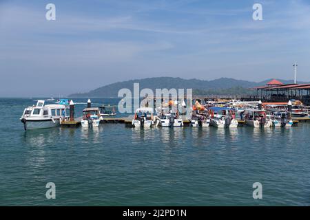 Kota Kinabalu, Malesia - 17 marzo 2019: Piccoli motoscafi con passeggeri sono ormeggiati vicino al terminal dei traghetti di Jesselton Point in una giornata di sole Foto Stock