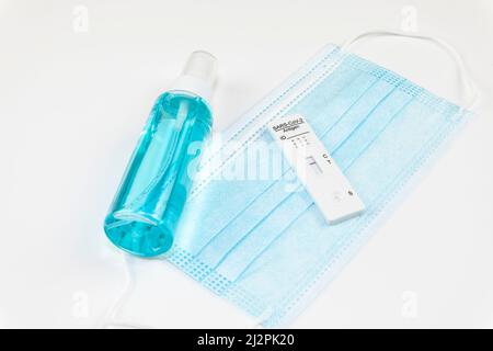 Risultato negativo del test Covid-19 con kit per test antigene rapido (ATK) SARS-COV-2 e maschera chirurgica protettiva su sfondo bianco. Test autodiagnostico per Coronav Foto Stock