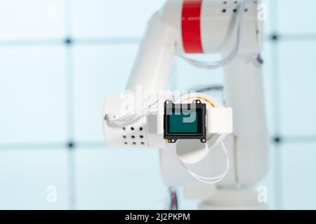 Braccio del robot con sensore di immagine a matrice CCD e CMOS nel manipolatore. Concetto sul tema della visione artificiale e del riconoscimento del modello Foto Stock