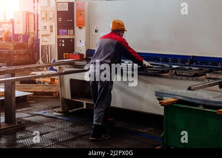 Operatore che lavora con pressa idraulica CNC. Foto Stock