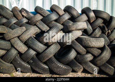 Parete dei vecchi pneumatici. Pneumatici usati per strada. Foto orizzontale. Foto Stock