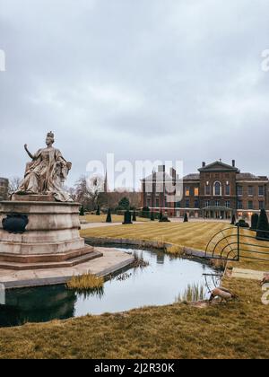 Statua della Regina Vittoria di fronte a Kensington Palace in una giornata nuvolosa ad Hyde Park, Londra Foto Stock