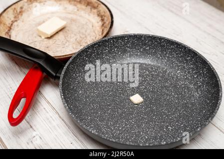 Confronto delle teglie. Padella vecchia e nuova. Cuocere la friggitrice con un minimo di olio. Preparazione di cibo sano. Foto Stock