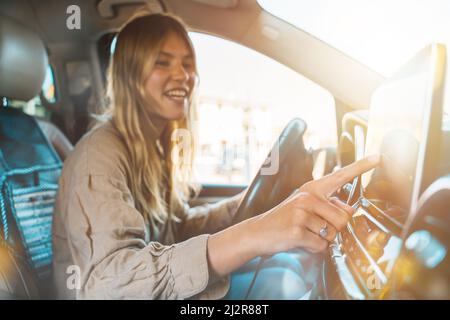 Donna seleziona la destinazione con il navigatore gps per auto Foto Stock