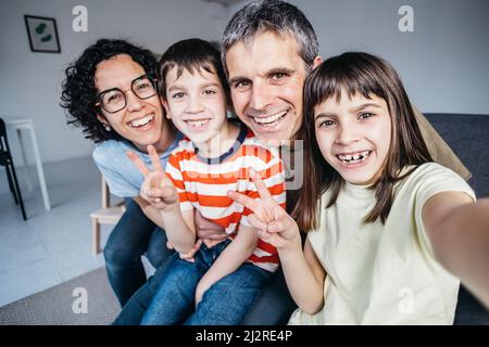 Famiglia felice prendere un selfie mentre godendo il tempo insieme a casa. Foto Stock