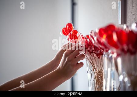 Lollipops rosso a forma di cuore sul bancone di un negozio di caramelle. Foto Stock