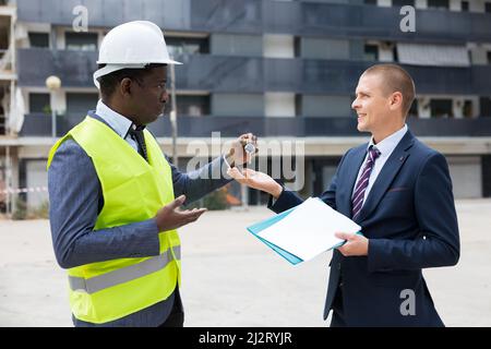 Uomo che riceve le chiavi per il nuovo appartamento da ingegnere Foto Stock