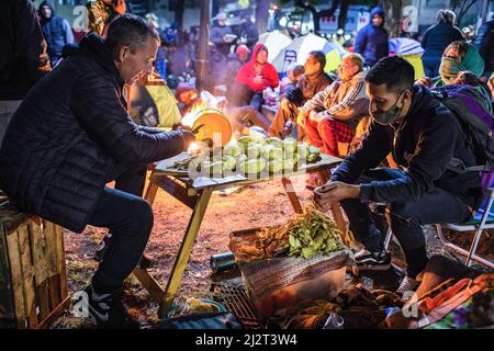 Buenos Aires, Argentina. 31st Mar 2022. Due uomini hanno visto sbucciare le patate per prepararle durante la prima notte del campo di 48 ore. Le organizzazioni politiche che compongono l'unità Piquetera tennero un campo su Avenida 9 de Julio, il viale più importante della città di Buenos Aires, Davanti al Ministero dello sviluppo sociale per 48 ore per denunciare la mancanza di risposta alle loro esigenze da parte del governo del Presidente Alberto Fernandez. (Foto di Nacho Boullosa/SOPA Images/Sipa USA) Credit: Sipa USA/Alamy Live News Foto Stock