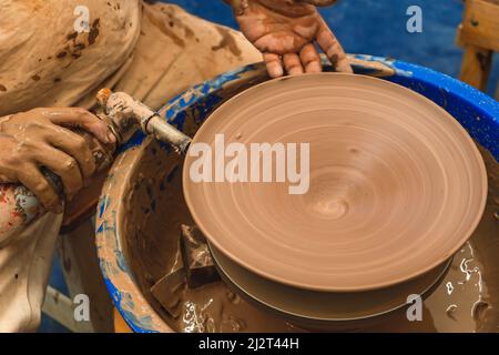 Primo piano di una torcia con fuoco che asciuga il pezzo formato sulla ruota del vasaio. Concetto di artigianale. Foto Stock