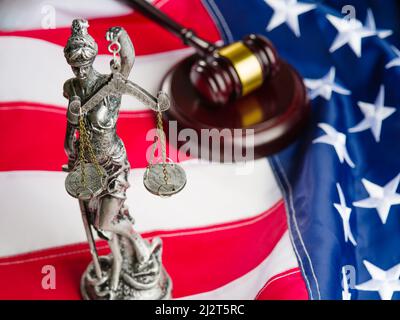 Scultura della dea della giustizia Themis, un gavel di legno del giudice sullo sfondo della bandiera nazionale degli Stati Uniti d'America. Freedo Foto Stock