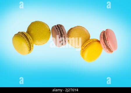 Dolci francesi tradizionali - macaroni multicolore su sfondo blu pallido. Cibo dolce pronto a mangiare. Ristorante, hotel, panetteria. Vacanza, compleanno, Foto Stock