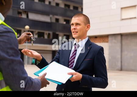 Uomo che riceve le chiavi per il nuovo appartamento da ingegnere Foto Stock