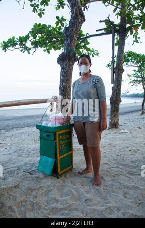 Una donna che vende bubur ijo zuppa di fagioli verdi a Kuta Beach, Bali al mattino presto. Foto Stock