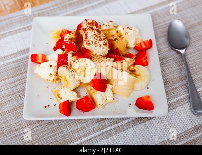 Porzione di gelato con fragole e banane a fette Foto Stock