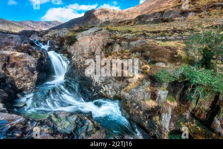 Limpido acqua di sorgente di montagna fresca, che scorre dal gallese, montagne Snowdonian nel Galles del Nord, in una chiara giornata di sole a metà marzo. Foto Stock