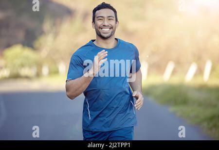 Ive è sempre stato uno per inseguire i miei sogni. Colpo di un bel giovane che corre da solo fuori durante il giorno. Foto Stock