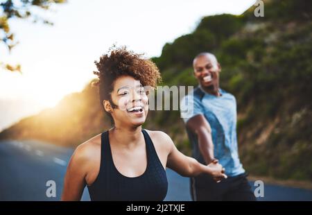 Esercitandosi soltanto li renderà il tatto migliore. Scatto corto di una giovane coppia felice fuori per una corsa insieme. Foto Stock