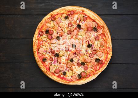 Pizza con vari tipi di salsicce sottili, cetrioli sottaceto, olive e cipolla rossa, vista dall'alto Foto Stock