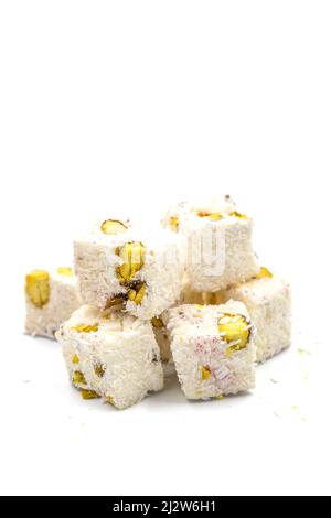 Turkish Delight doppio arrosto Sultan Wick con fiocchi di cocco, isolato su uno sfondo bianco. Primo piano pistacchio turco delizia. Turkis tradizionale Foto Stock