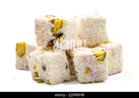 Turkish Delight doppio arrosto Sultan Wick con fiocchi di cocco, isolato su uno sfondo bianco. Primo piano pistacchio turco delizia. Turkis tradizionale Foto Stock