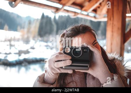 Giovane donna che fotografa con la macchina fotografica retrò Instant film per un'immagine in stile vintage. Foto Stock