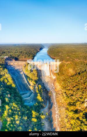 Straripante diga di Warragamba sul fiume Blue Mountains in Australia - panorama verticale aereo. Foto Stock