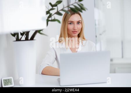 Medico femminile cosmetologo utilizzando il computer portatile in salone di bellezza Foto Stock