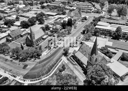 Vista in scala di grigi ad alto contrasto di Church Street con chiese cattoliche storiche nel centro di Wagga Wagga, città australiana - paesaggio urbano aereo. Foto Stock