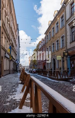 Una strada con edifici colorati nella Città Vecchia di riga, Lettonia con un po' di neve sul terreno Foto Stock