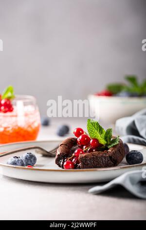 Torta di Lava al cioccolato caldo con frutti di bosco Foto Stock