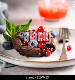 Torta di Lava al cioccolato caldo con frutti di bosco Foto Stock