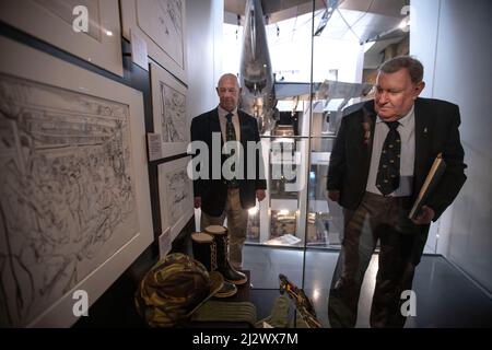 ALl'IWM LONDON New Falklands sono APERTE NUOVE ESPOSIZIONI ALL'IWM London New Falklands, che includono immagini del fotografo professionista Paul Haley e opere d'arte di Linda Kitson. (Nella foto) il veterano delle Falklands Mike Carr, che ha servito con 3 Para con Paul Carr insieme al veterano delle Falklands Paul Benton, che ha servito a bordo di HMS Invincible, si è fermato accanto ad un banco espositore che mostra il kit di sketching di Lara Kitsens e l'abbigliamento militare che ha usato durante il conflitto delle Falklands. Credit: Jeff Gilbert/Alamy Live News Foto Stock