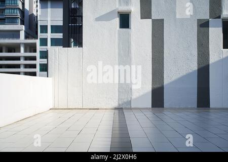 Pavimento vuoto con parete a righe bianche, grigie e nere Foto Stock