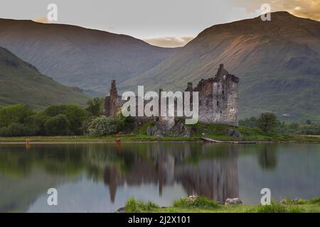 Vista su Loch AWe fino alle rovine del castello di Kilchurn, Scozia, Regno Unito, con bestiame delle Highland Foto Stock