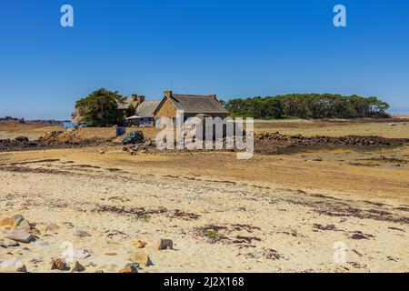 Spiaggia di sabbia con cottage a bassa marea sulla Costa Rosa Granite in Bretagna, Francia, Europa occidentale Foto Stock
