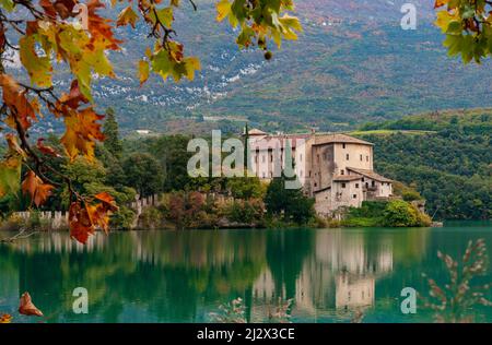 Lago Toblino con il castello in forma autunnale. È un piccolo lago alpino in provincia di Trento (Trentino-Alto Adige) ed è stato dichiarato Biotopo per le sue qualità naturalistiche. Posizione utilizzata per la produzione di pellicole. Italia Foto Stock