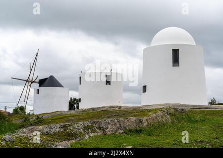 Evora, Portogallo - 24 marzo 2022: I mulini a vento di Sao Bento di Evora sotto un cielo sovrasparato espressivo Foto Stock
