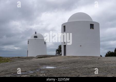 Evora, Portogallo - 24 marzo 2022: I mulini a vento di Sao Bento di Evora sotto un cielo sovrasparato espressivo Foto Stock