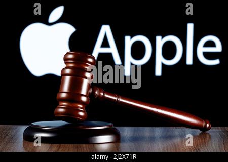 Gavel sul tavolo sullo sfondo del logo della società Apple. Il concetto della prova. Foto Stock