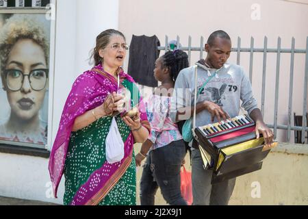 Nakuru, Kenya. 03rd Apr 2022. I devoti di Hare Krishna Consciousness Nakuru Center cantano mantra e suonano uno strumento musicale all'esterno di un barbiere lungo una strada governativa. La coscienza di Hare Krishna, comunemente conosciuta come il movimento di Hare Krishna, un ramo dell'induismo, crede che cantare i nomi di Dio sia un modo potente di meditazione, e dovrebbe essere cantato per le strade per far sì che gli altri possano beneficiarne. I devoti di Hare Krishna mangiano carne, credono che gli animali siano figli di Krishna, creati da Dio, e donít shouldnít essere feriti. Credit: SOPA Images Limited/Alamy Live News Foto Stock