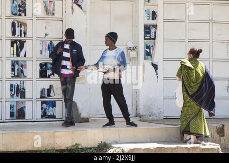 Nakuru, Kenya. 03rd Apr 2022. Un devoto di Hare Krishna Consciousness Nakuru Center visto consegnare un libro a un uomo lungo una strada del governo. La coscienza di Hare Krishna, comunemente conosciuta come il movimento di Hare Krishna, un ramo dell'induismo, crede che cantare i nomi di Dio sia un modo potente di meditazione, e dovrebbe essere cantato per le strade per far sì che gli altri possano beneficiarne. I devoti di Hare Krishna mangiano carne, credono che gli animali siano figli di Krishna, creati da Dio, e donít shouldnít essere feriti. Credit: SOPA Images Limited/Alamy Live News Foto Stock