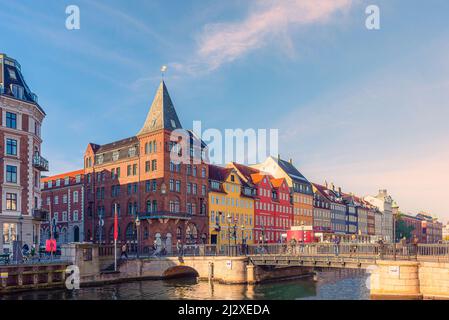 Nyhavn ponte attraverso un canale con vecchie navi, case colorate e una vecchia chiesa di Sømandskirken a Copenhagen, Danimarca Foto Stock