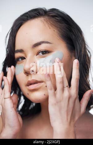 Il sapone e l'acqua non sono sufficienti. Studio girato di una bella giovane donna con cerotti sotto gli occhi. Foto Stock