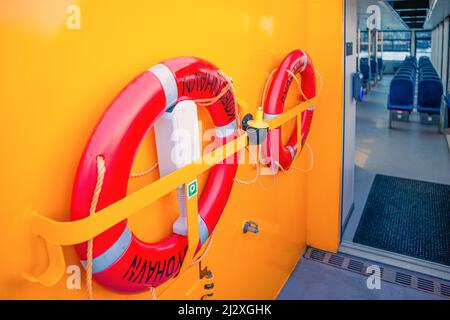 Due boe di vita rosse rotonde appendono sul ponte di una nave Copenhagen Harbour Bus. Danimarca Foto Stock